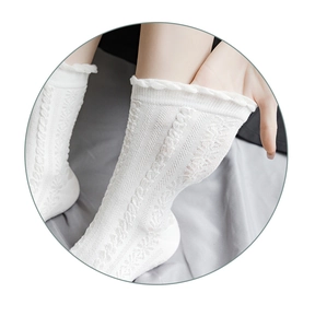 Dettaglio di calze bianche in maglia traforata con bordi a volant per uno stile JK Lolita