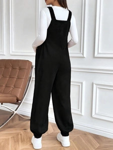 Rear view of stylish black corduroy maternity overalls featuring adjustable waist buttons