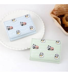 Dettaglio dei portafogli in ecopelle con motivo panda blu e verde su piatto bianco