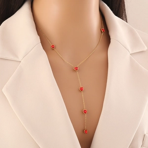 Golden Y-shaped stainless steel necklace with five red glass heart pendants on model