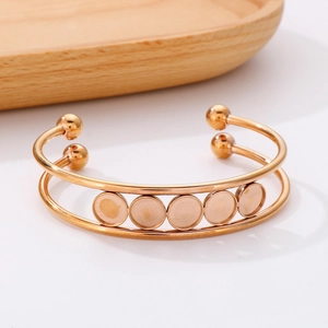 Detail of rose gold double-layered open bangle with five circular DIY inlay trays