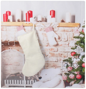 Cream white fabric Christmas stocking hanging on a festive mantel with pine cones
