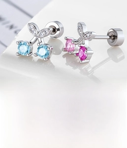 Macro shot of silver cherry earrings with blue and pink cubic zirconia and screw backings