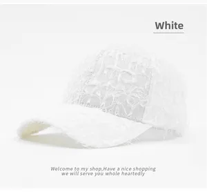 Detail of white sun visor baseball cap featuring unique fringe and frayed texture design