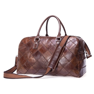 Detailed close-up of dark brown leather travel bag featuring diamond quilted pattern and silver hardware