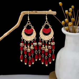 Bohemian ethnic red tassel earrings with gold crescent drop on natural wood branch