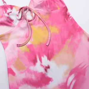 Detail of V-neck tie and vibrant pink yellow tie-dye print on the summer dress