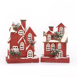 Set of two red wooden Christmas light-up cabins with snow and pine decorations
