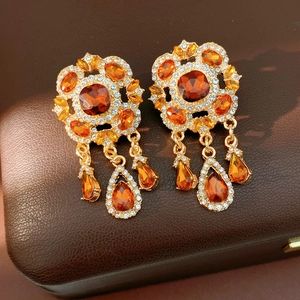 Nahaufnahme von Vintage-Ohrringen mit bernsteinfarbenen Tropfen und Strass-Details