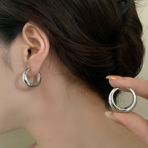 Minimalist silver chunky hoop earrings worn by a model for a modern luxury look