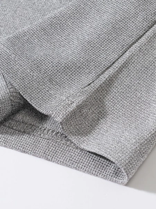Detail of silver metallic knit fabric showing the fine texture and shimmering threads