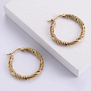 Polished gold twisted hoop earrings for women on a minimalist white display