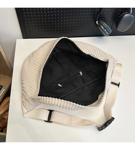 Detail view of corduroy crossbody bag interior with mesh pockets and black lining