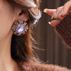 Close-up of vintage square earring with purple gemstone and antique bronze finish