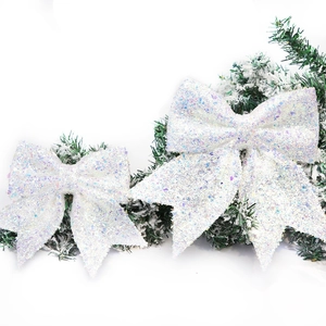 Sparkling white Christmas tree bows with iridescent glitter and festive pine needles