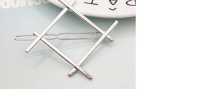 Macro shot of silver geometric metal hair clip with a modern minimalist hashtag design