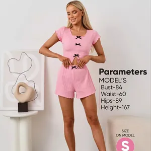 Pink rib-knit pajama set with crop top, short sleeves, and black decorative bows
