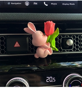 Detailed close-up of a pink bunny figurine holding a red tulip on a car air vent clip