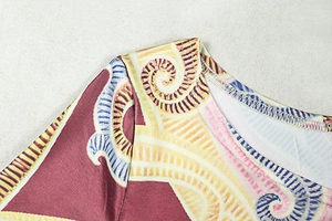 Close-up of neckline stitching and complex paisley floral pattern on long sleeve bodysuit