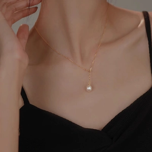 Close-up of a single natural freshwater pearl pendant on a gold Y-shaped chain