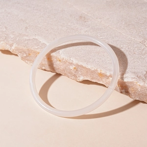 Vue détaillée d'un bracelet en acrylique blanc semi-transparent sur une surface en pierre