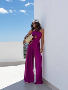 Detail of fuchsia halter jumpsuit featuring side waist cut-outs and flowing wide-leg silhouette