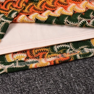 Détail du tissu crocheté coloré avec motifs ondulés et doublure intérieure beige lisse