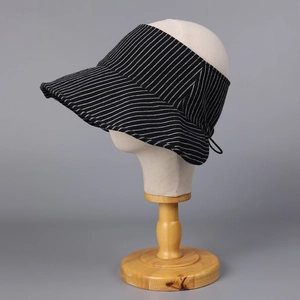 Dettaglio cappello visiera a righe con cordoncino regolabile e tesa larga per protezione solare