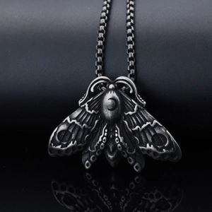 Gothic vintage silver moth necklace with moon engraving on black leather background