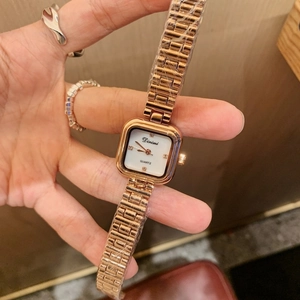 Close-up of rose gold square watch with shell dial and protective film on metal band