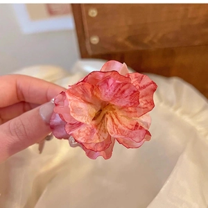 Close-up of pink and orange gradient fabric rose hair claw clip with delicate petal texture