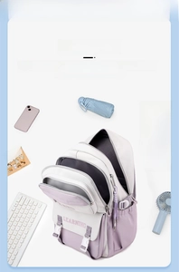 Detail view of purple and white student backpack with school supplies and many pockets