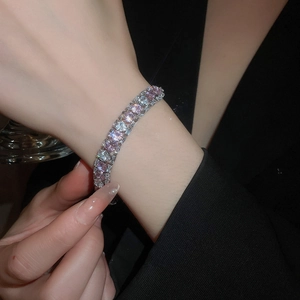 Macro shot of tennis bracelet with alternating pink and clear zircons on silver base