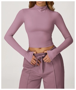 Detailed view of quick-dry yoga top cuffs with thumb holes and mock neck design