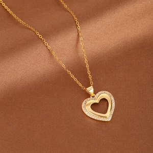 Luxurious gold hollow heart pendant necklace with micro-pave zircons on silk background
