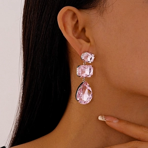 Dettaglio di orecchini di lusso con cristalli rosa con tagli quadrati e a goccia