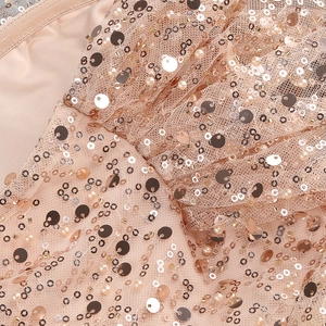 Detailed close-up of champagne sequins and faux pearls on high-density mesh fabric