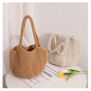 Detail of hand-woven cotton shoulder bags in caramel and cream showing knit texture