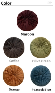 Detail showcasing velvet pumpkin cushions in burgundy, brown, green, orange and peacock blue