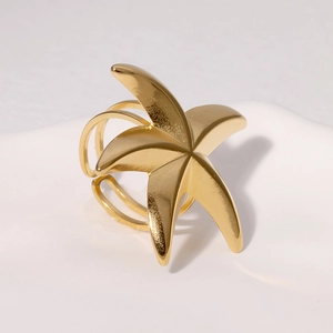 Minimalist gold starfish ring for women made of stainless steel on white pedestal