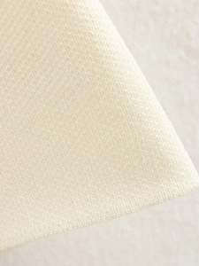 Detailaufnahme der cremeweißen Stricktextur und weichen gewebten Stofffasern