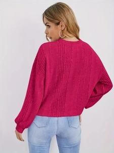 Détail d'un pull en tricot côtelé rouge rose avec manches lanternes et texture