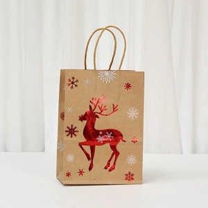 Detailed view of brown kraft Christmas gift bag with metallic red reindeer and white snowflakes