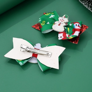 Detail of Christmas snowman hair clips with green ribbons and red sequin bow