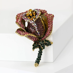 Detail of rose brooch with magenta rhinestones and vintage bronze metal finish