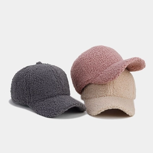 Detailed close-up of warm lamb wool baseball caps in grey, pink and beige colors