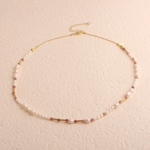 Detail of baroque freshwater pearl necklace with pink beads and gold metal tubes