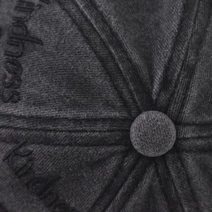 Macro shot of embroidered kindness text on black corduroy baseball cap top detail