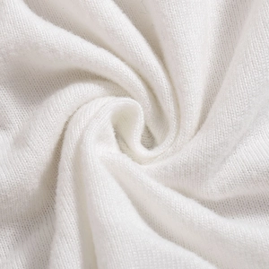 Macro shot of white knitted fabric texture showing high-density woven details of the dress
