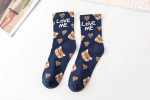 Detail of navy knit socks featuring orange fox patterns and Love Me text motifs